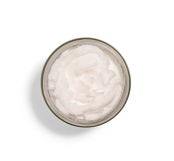 A top‑down view of an open jar filled with smooth, whipped white cream.