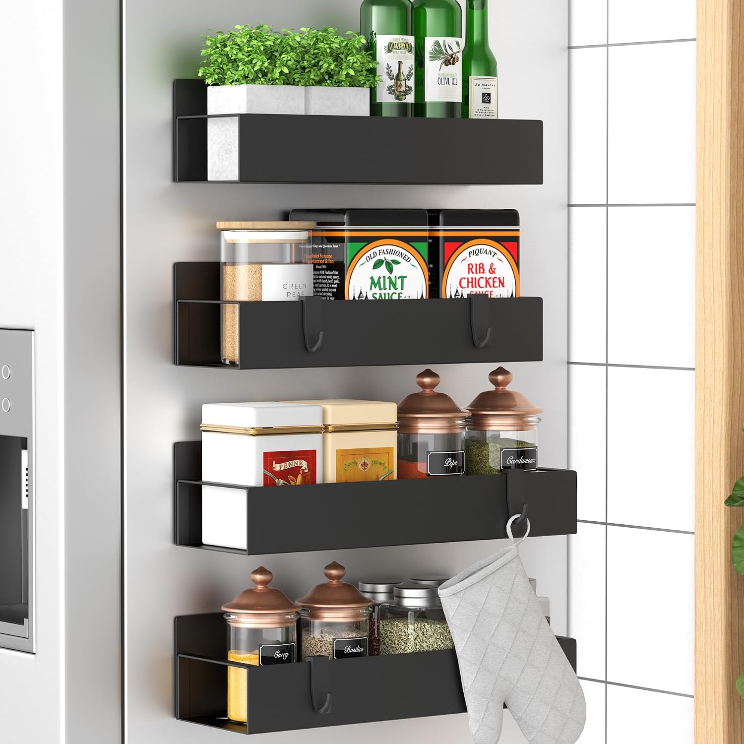 Black magnetic spice racks mounted on the side of a refrigerator, holding spices, seasonings, oils, herbs, and kitchen essentials.